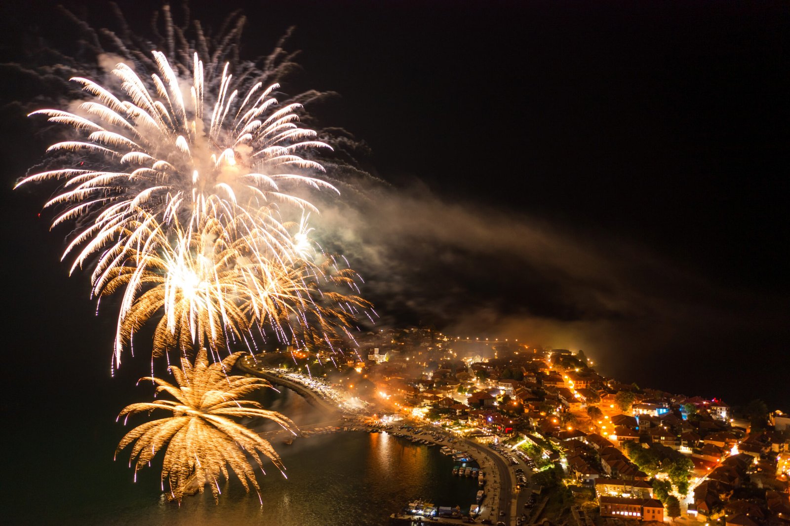Fogos de artifício iluminam o céu noturno durante uma festa popular em Portugal.
