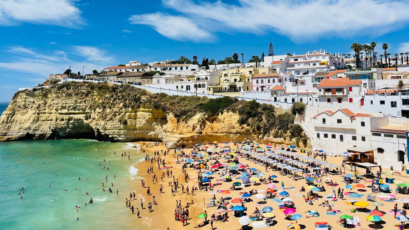 Praia Ericeira em Portugal cheia de famílias e turistas, representando qualidade de vida para expatriados.